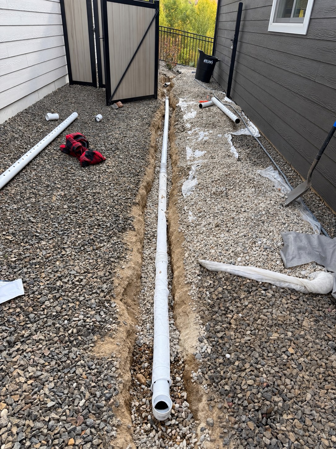 Drain pipe being installed in a trench beside the house
